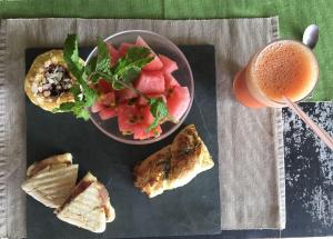 a plate of food with a bowl of fruit and a drink at Casa Namoa Pousada in Ilha de Boipeba