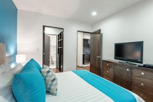 a bedroom with a large bed and a flat screen tv at Suites Copérnico Polanco Anzures in Mexico City
