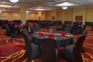 un salón de banquetes con mesas y sillas y servilletas rojas en MCM Elegante Hotel & Suites Lubbock, en Lubbock