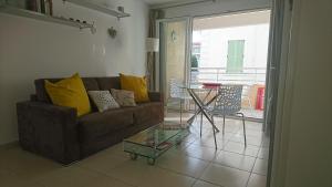ein Wohnzimmer mit einem Sofa und einem Glastisch in der Unterkunft Nicolas 8 in Cannes