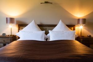 a bedroom with a large bed with white pillows at Hofgut Holzmuhle in Germersheim
