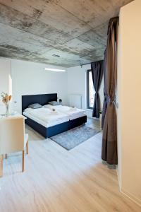 1 dormitorio con 1 cama grande y techo de madera en Exclusive penzion Viva Residence en Mladá Boleslav