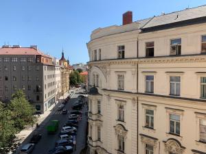 une rue de la ville avec des voitures garées et des bâtiments dans l'établissement VIP city CENTER apartment Prague, à Prague
