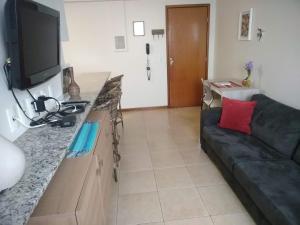 sala de estar con sofá y TV de pantalla plana en Ipê Rosa Apartamento, en Brasilia