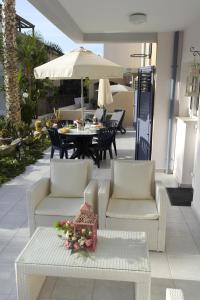 een patio met een tafel en stoelen en een parasol bij Maya's Apartment - Complimentary Paphos Airport Transport in Paphos City