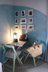 een tafel en stoelen in een kamer met een blauwe muur bij La Porta Accanto B&B in San Vito di Leguzzano