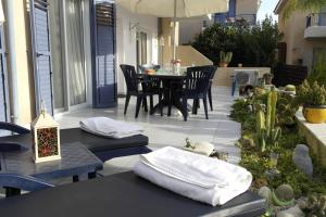 パフォスにあるMaya's Apartment - Complimentary Paphos Airport Transportの椅子とタオルが置かれたテーブルのあるパティオ