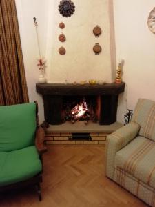 a living room with a fireplace and a green chair at Casa Bruno in Roccaraso, sentirsi a casa propria in Roccaraso