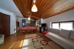 un soggiorno con divano e tavolo di Residence Alpen Casavacanze a Pinzolo