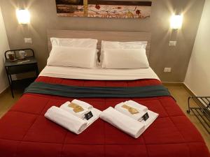 a bedroom with a large bed with towels on it at Kings Of Rome Apartments in Rome