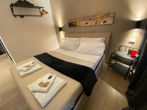 ローマにあるKings Of Rome Apartmentsのベッド1台(タオル2枚付)が備わる小さなホテルルームです。
