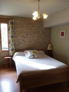 1 cama en un dormitorio con pared de ladrillo en La Mare Chambres d'Hôtes Chaix accueil, en Étoile-sur-Rhône