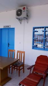 een kamer met een tafel en stoelen en een ventilator bij OCEAN-SI MAnsion in Kribi