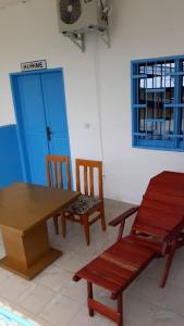 a table and two chairs and a table and a door at OCEAN-SI MAnsion in Kribi