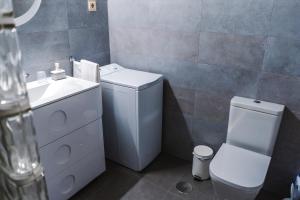 a small bathroom with a toilet and a sink at Apartamento Victoria con parking incluido in Ronda +3 photos