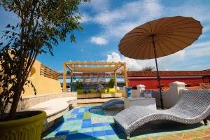 patio z 2 krzesłami i parasolem w obiekcie Casa Logos Hotel Boutique w mieście Cartagena de Indias