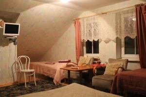 a room with two beds and a table and chairs at Aikarali Home Accommodation in Haapsalu