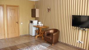 a room with a table and a refrigerator and a chair at Molex Apartments in Chernihiv