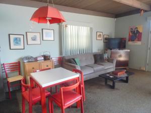 a living room with a couch and a table with red chairs at 196 Front Street in Avila Beach