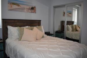 Una cama con sábanas blancas y almohadas en un dormitorio en 245 San Miguel en Avila Beach