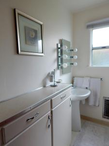 a white bathroom with a sink and a toilet at 141 A 1st Street in Avila Beach