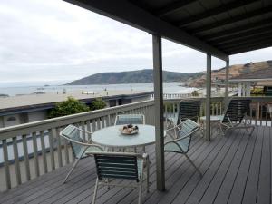 a table and chairs on a deck with a view of the beach at 141 A 1st Street in Avila Beach