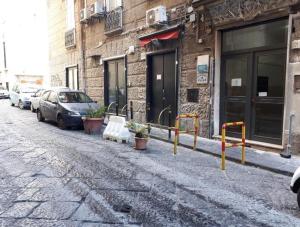 una strada con auto parcheggiate sul lato di un edificio di B&B Napoli Campagnari a Napoli