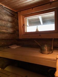 una cocina con ventana en una cabaña de madera en Villa Kelotupa, en Hossa 32 fotos más
