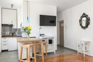 a kitchen with white cabinets and a table with stools at Aldo apartment in Split