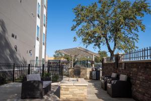 a patio with couches and a tree next to a building at Comfort Suites Cedar Park - Austin Northwest in Cedar Park