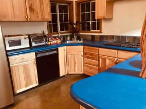 cocina con armarios de madera y lavavajillas negro en A Lovely Cabin House at Way Woods Retreat with Outdoor Hot Tub! - By Sacred Hub MGMT en Foresthill