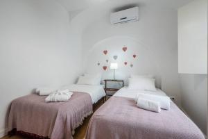 two beds in a room with hearts on the wall at Home in one of Évora´s most historical squares in Évora