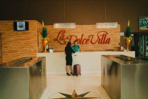 a woman standing at a counter with her luggage at La Dolce Villa in Avar&eacute;
