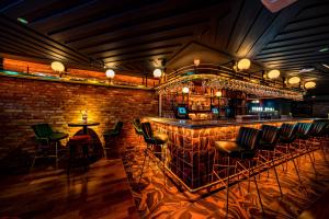 a bar with green chairs and a brick wall at The Old Quarter Townhouse in Limerick