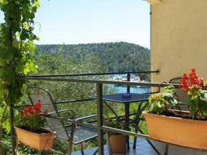 un balcone con tavolo, sedie e fiori di Apartments & Rooms Formenti a Skradin