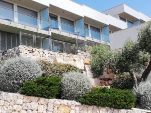 an apartment building with a stone wall and trees at Casamuler in Peniscola