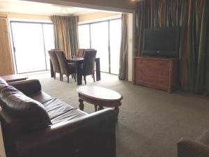 uma sala de estar com um sofá e uma mesa com cadeiras em Polynesian Oceanfront Hotel em Myrtle Beach