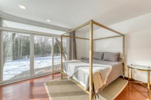 a bedroom with a canopy bed and a large window at Contemporary Maine Retreat in Bethel