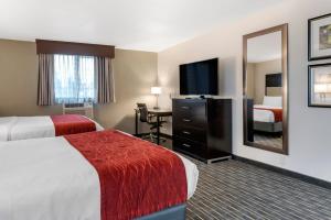 a hotel room with two beds and a flat screen tv at Comfort Inn & Suites Tigard near Washington Square in Tigard