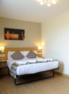 a bedroom with a bed with two pillows on it at Kings Cross Inn Hotel in London