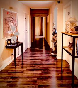 un pasillo con suelo de madera y un pasillo con mesas en Emme B&B, en Messina
