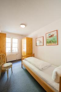 a bedroom with a large bed and a chair at Ferienwohnungen zum Nachtwächter in Meersburg