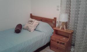 um quarto com uma cama e uma mesa de cabeceira com um candeeiro em Phaistos Country House em Mitrópolis