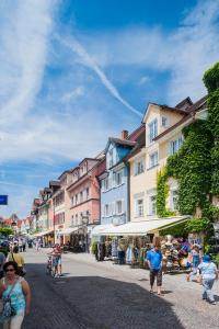 a group of people walking down a city street at Ferienwohnungen zum Nachtwächter in Meersburg