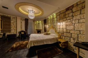 una camera da letto con un letto e un muro di pietra di Chateau Rond Boutique Hotel & Spa a Kato Loutraki