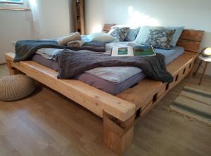 a wooden bed with a book on top of it at Hillside Bio Resort Delux Apartments in Šešče pri Preboldu