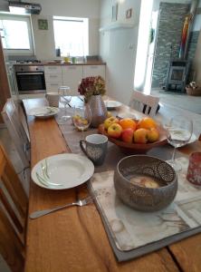 - une table en bois avec un bol de fruits dans l'établissement Hillside Bio Resort Delux Apartments, à Šešče pri Preboldu