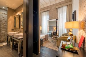 a hotel room with a bathroom and a bedroom at DOM Hotel Roma - Preferred Hotels & Resorts in Rome