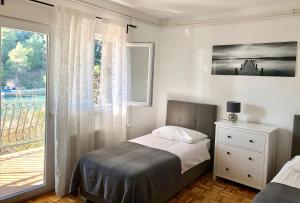 a bedroom with a bed and a large window at Apartments & Rooms Formenti in Skradin