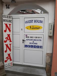 una puerta delantera de un hostal con carteles en ella en Guest House Nana, en Mostar